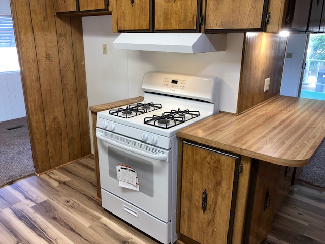 Kitchen with gas stove and wood cabinets in Exeter CA mobile home for sale, Unit 101