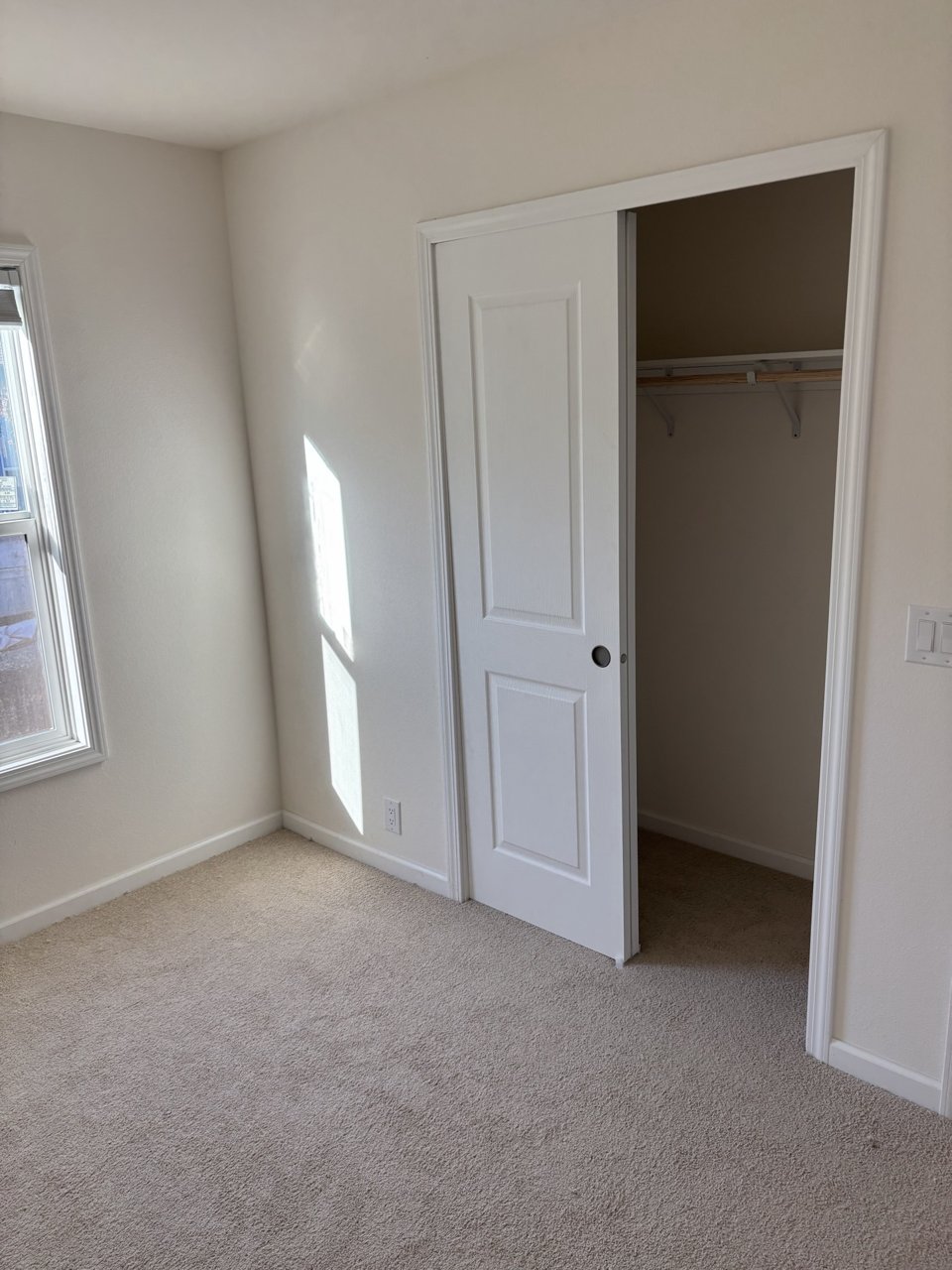 Carpeted bedroom with a closet