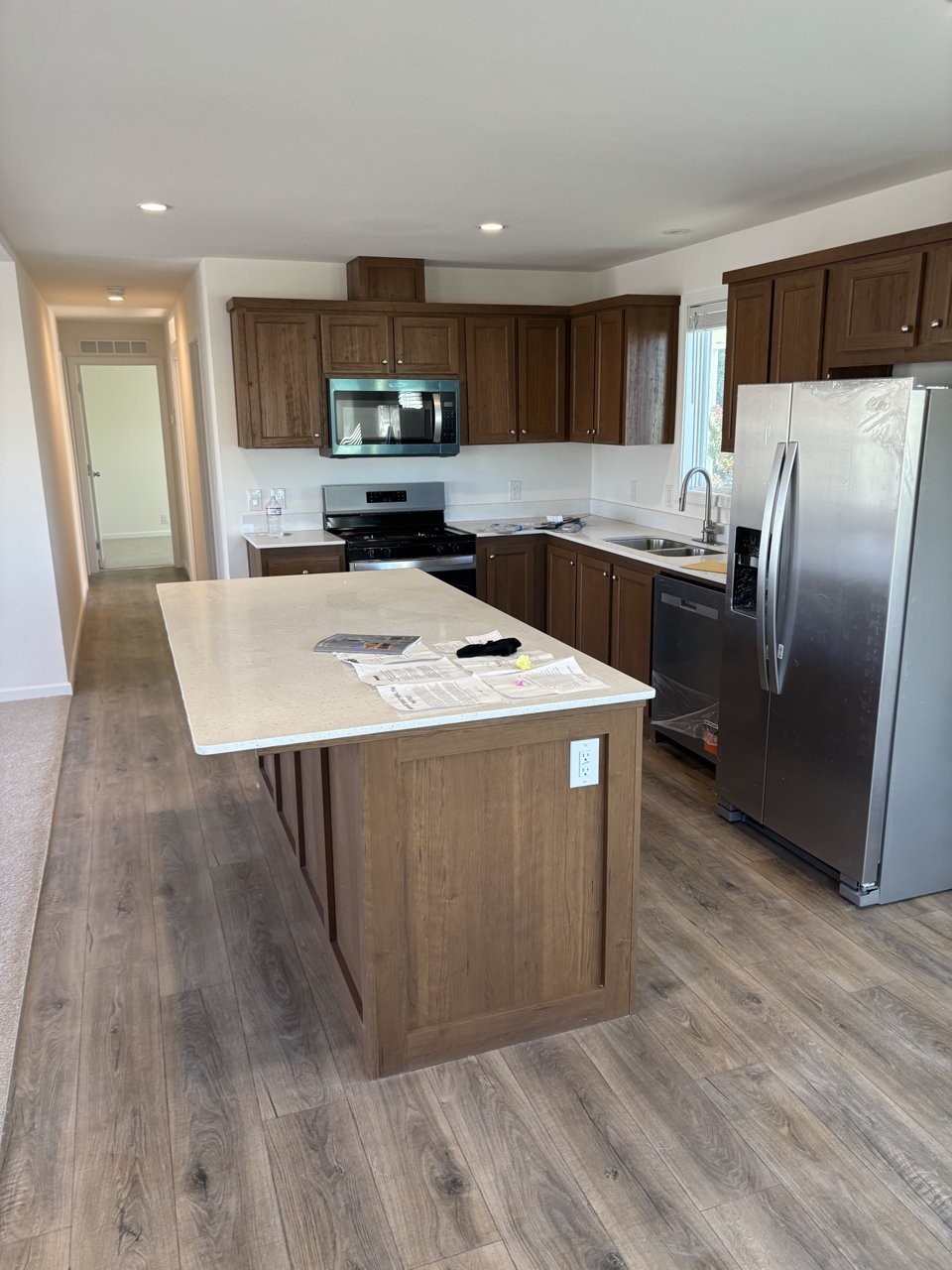 Kitchen with wood cabinetry, stainless steel appliances, and an island