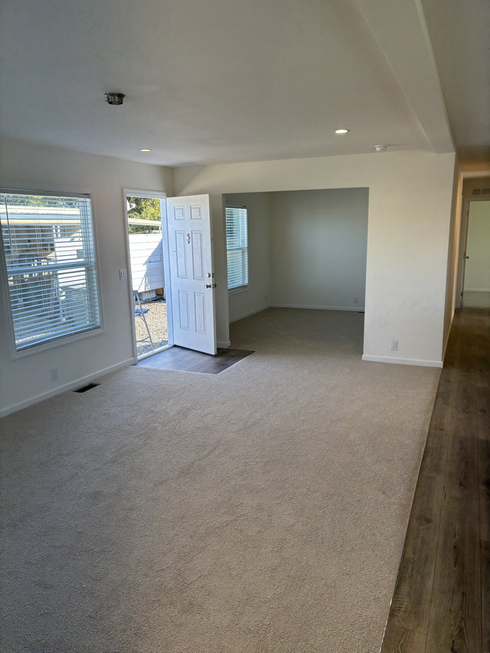 Bright living room with large windows and a ceiling fan